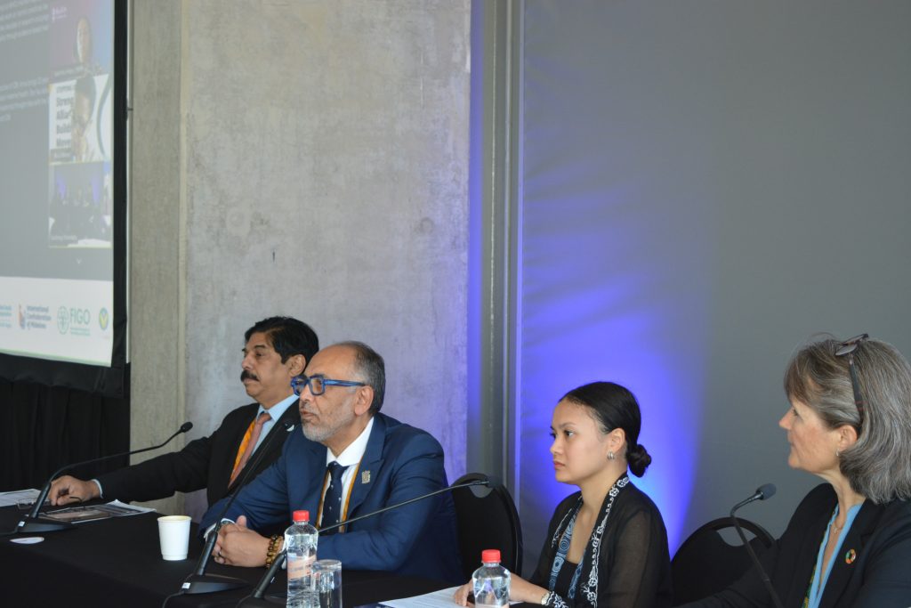 Four panellists Prof Hrishikesh Pai (FIGO Trustee for Asia and Oceania), Prof Hassan Shehata (RCOG Senior Vice President), Dr Hannah Nazri, Anna af Ugglas (ICM Chief Executive) seated at a table during a conference session, with microphones in front of them.